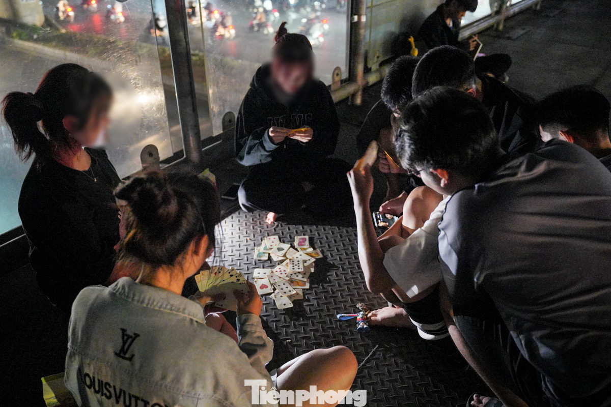 Toàn bộ không gian của cầu vượt đều bị chiếm dụng, nhiều người ngồi chơi bài.