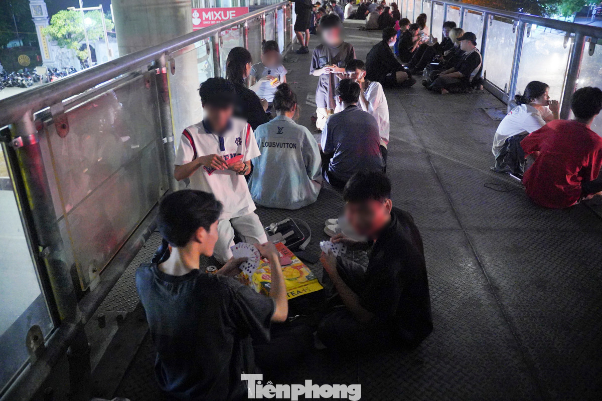 Toàn bộ không gian của cầu vượt đều bị chiếm dụng, nhiều người ngồi chơi bài.