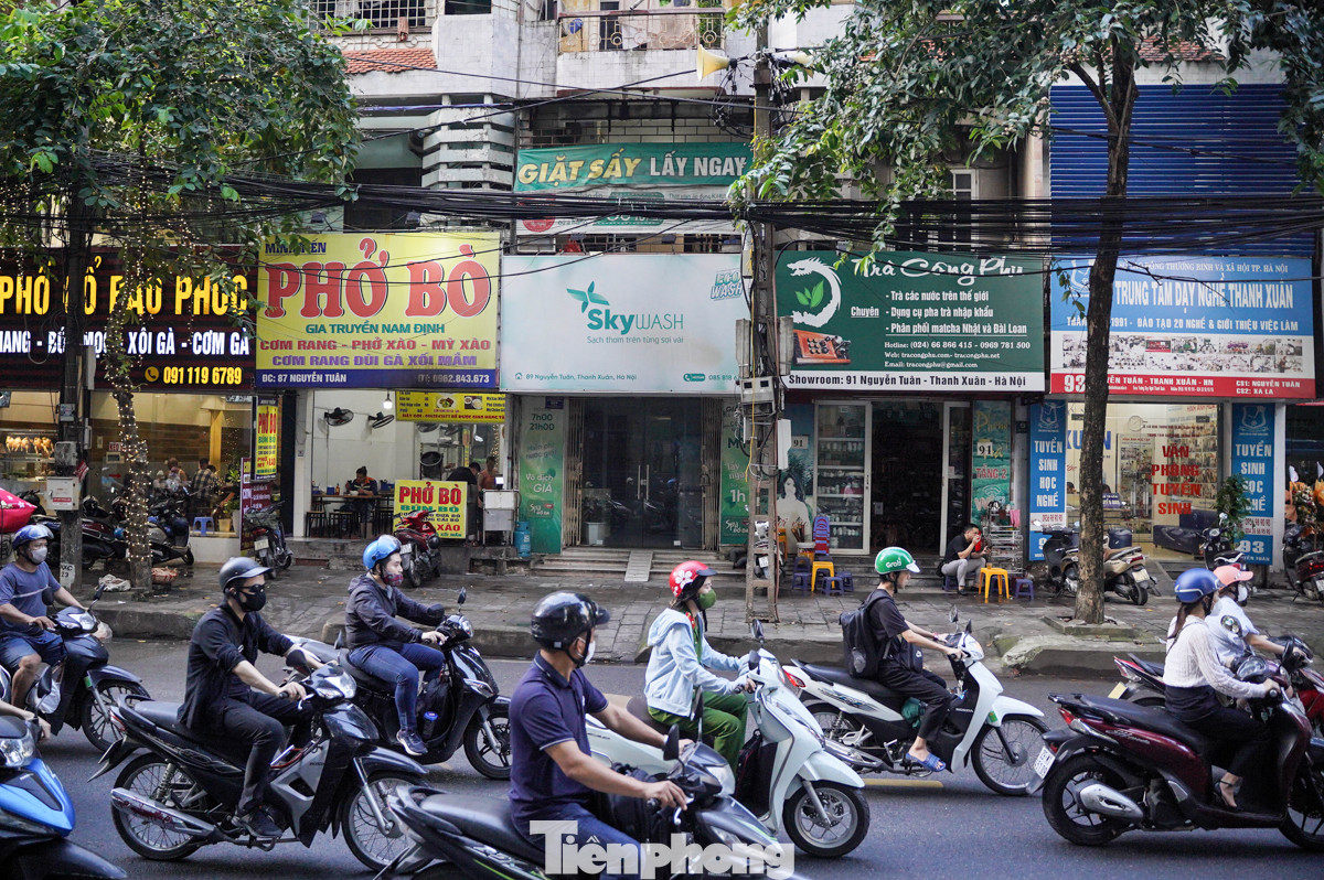 Dọc 2 bên đường san sát hàng quán buôn bán. Hàng hóa, đồ dùng nấu ăn được chủ kinh doanh bày bán chiếm dụng vỉa hè.