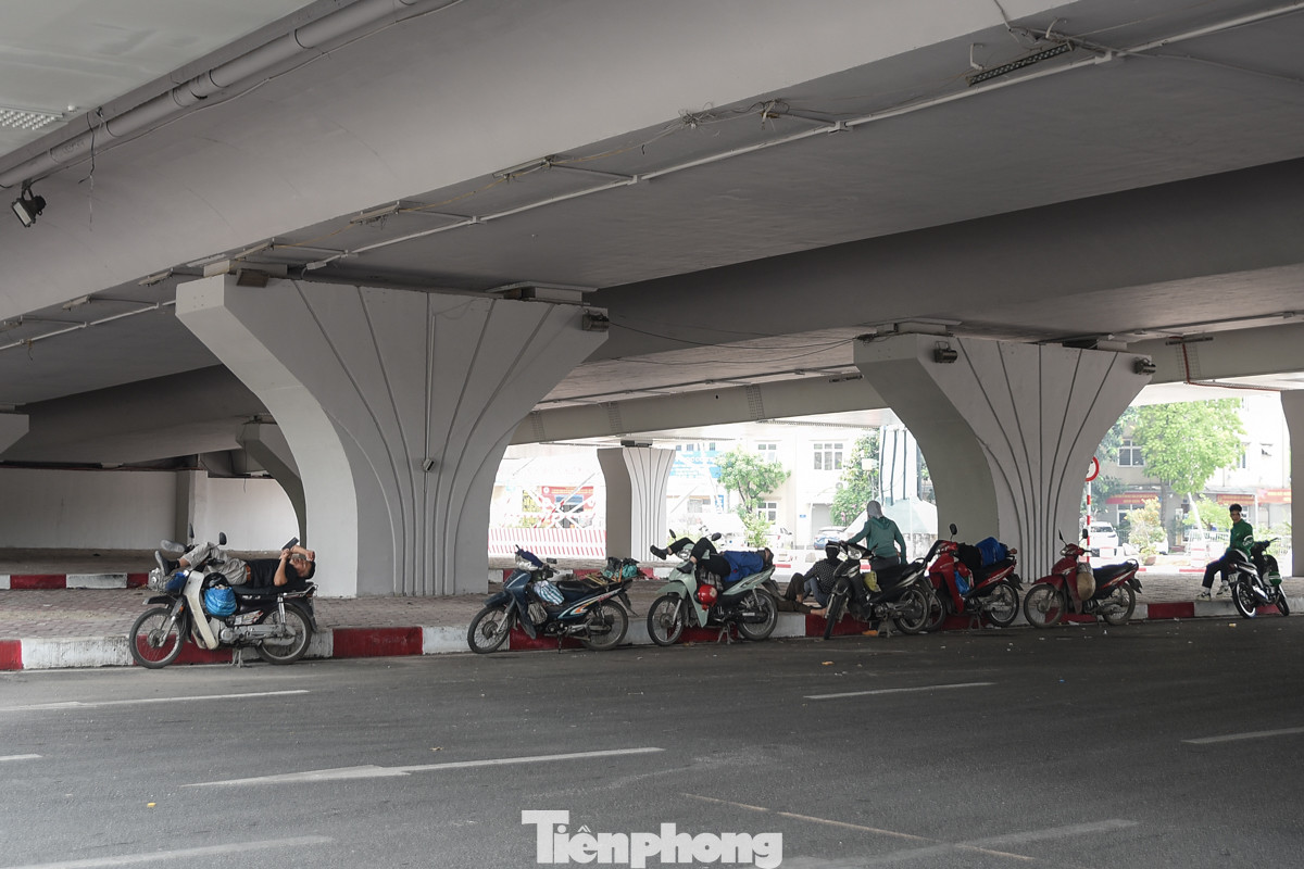 Hàng dài người lao động nghỉ ngơi phía dưới gầm cầu Mai Dịch.