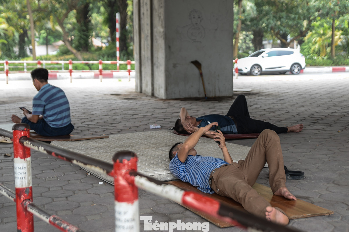 Dưới gầm chân cầu vượt vành đai 2, nhiều người lao động trải chiếu ra nằm nghỉ trưa.