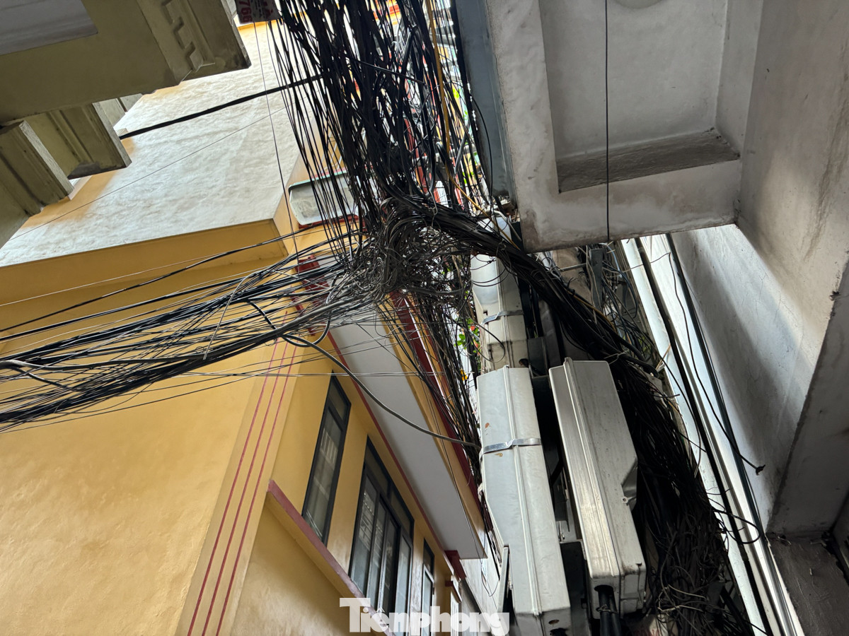 Bên dưới đủ các loại dây cáp thông tin, dây điện giăng như "mạng nhện" án ngữ các điểm giao cắt trong ngõ.