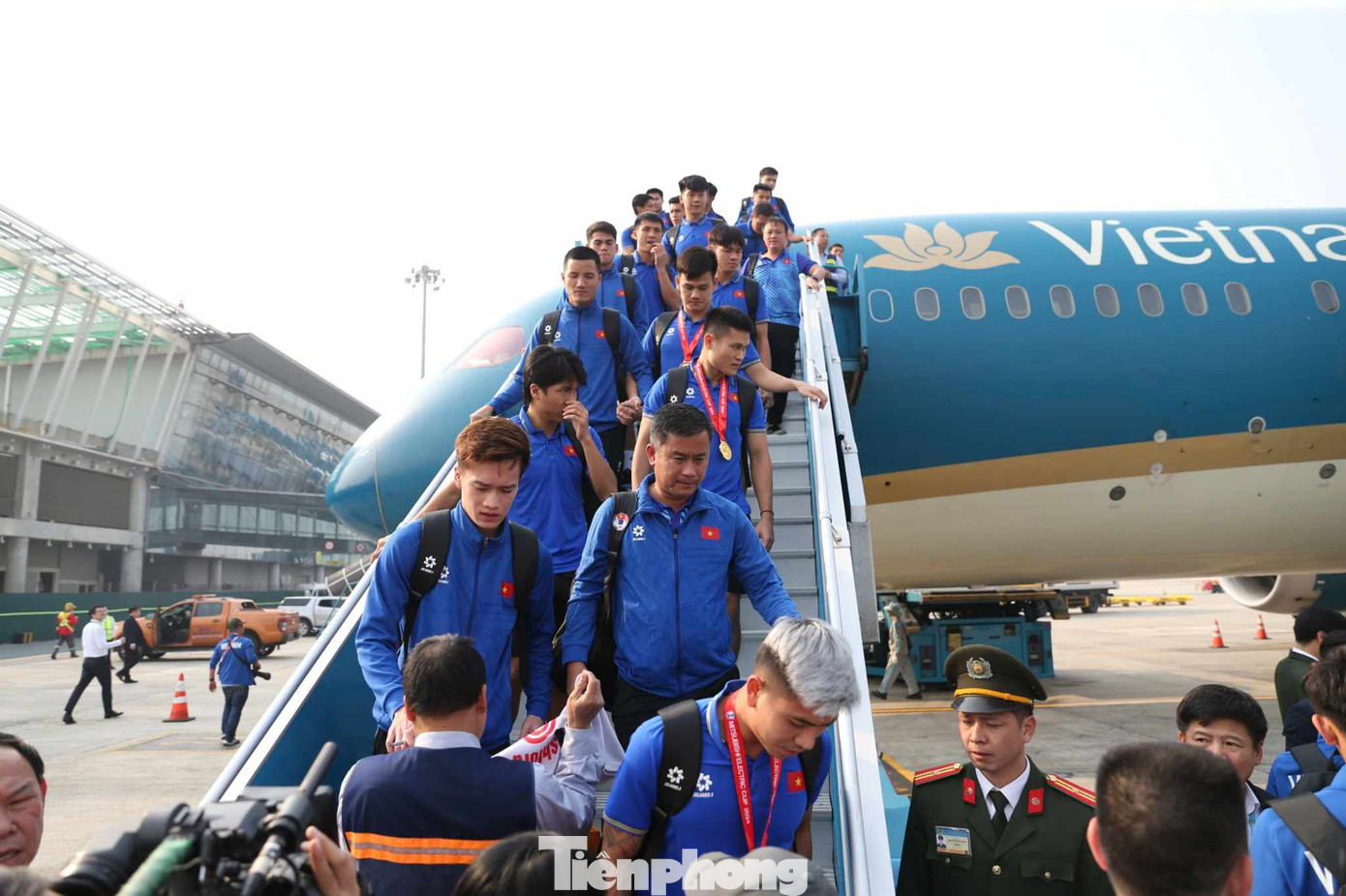 Các cầu thủ tuyển Việt Nam xuống máy bay, cầm theo chiếc cup vô địch trong không khí hân hoan.