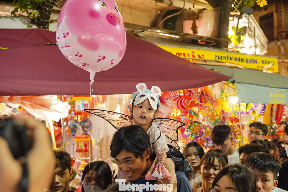 Từ Gia Lâm, anh Tú đưa con sang phố Hàng Mã để mua đồ chơi và bóng bay. "Dù khá đông đúc và đi lại khó khăn nhưng tôi chỉ cần con vui là được", anh Tú nói.
