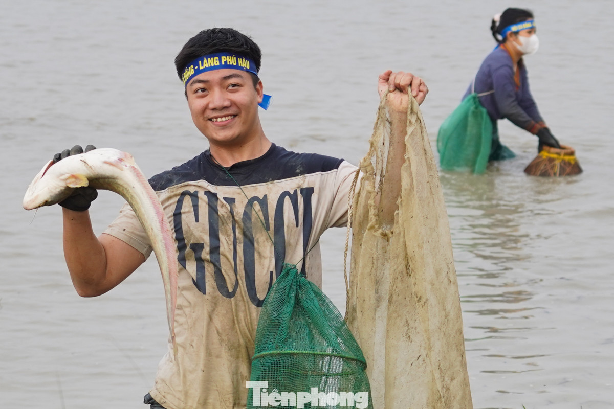 Người dân vui mừng bắt được cá to tại hội làng.
