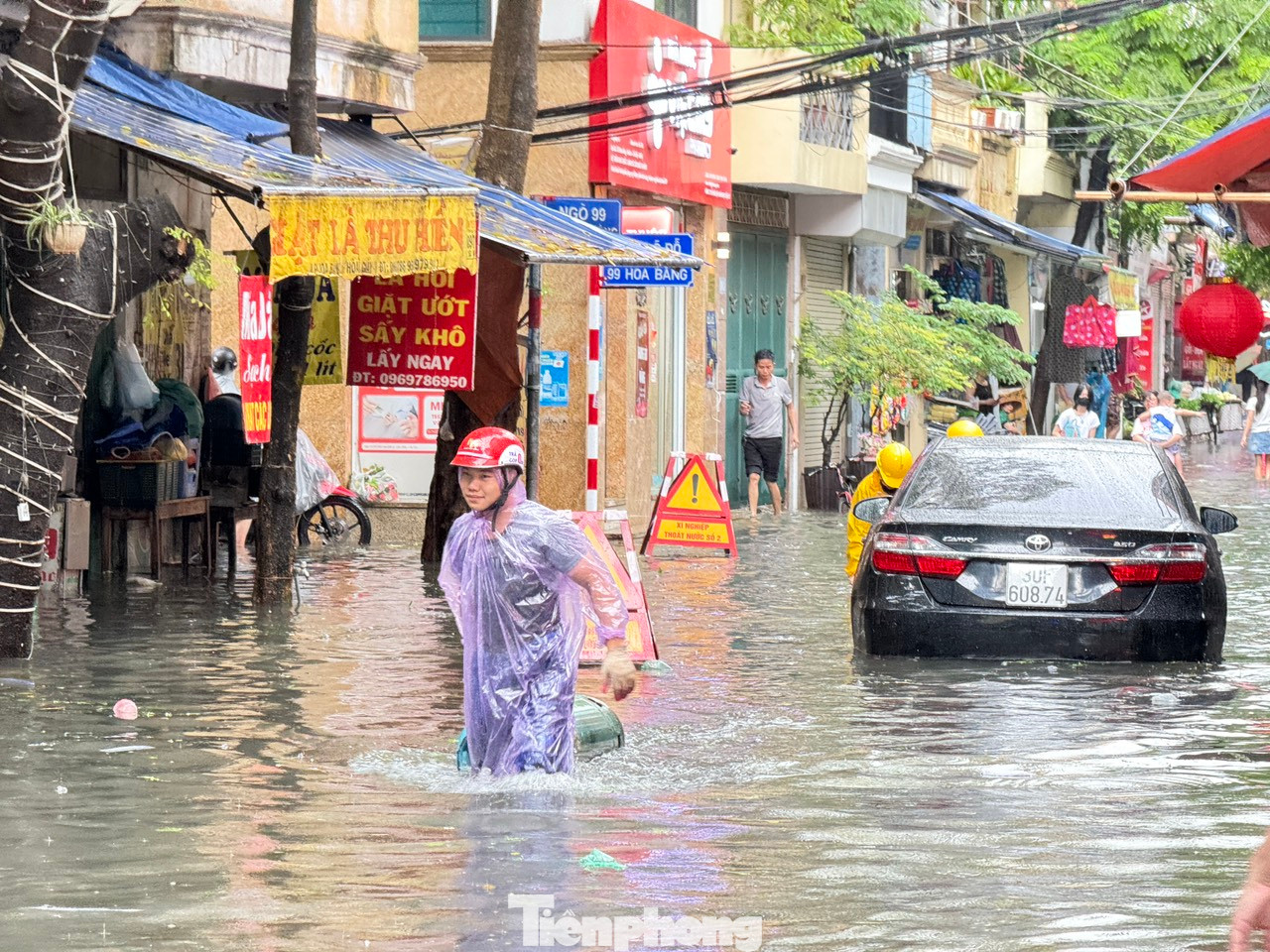 Ghi nhận tại phố Hoa Bằng (quận Cầu Giấy) lúc 9 giờ, đường ngập đến đầu gối, người dân di chuyển khó khăn, các phương tiện "chết đứng" giữa đường.