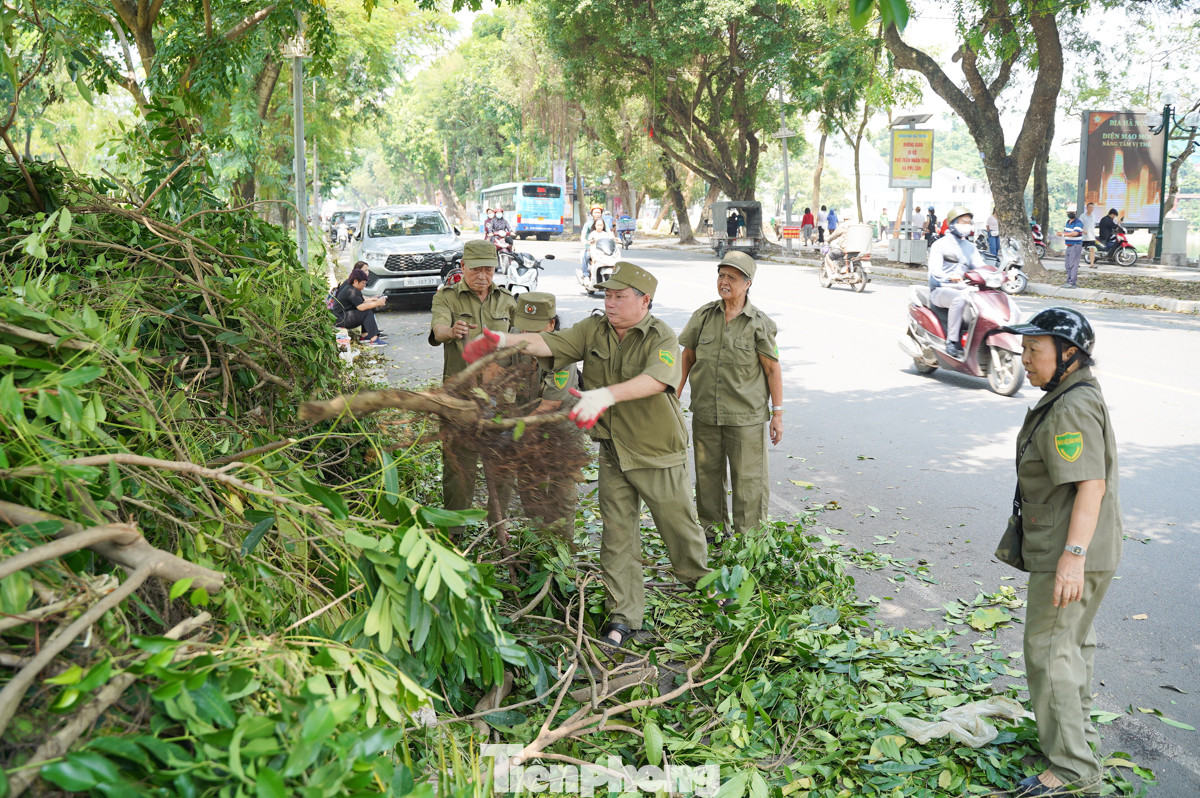 Từ sáng sớm, lực lượng bảo vệ dân phố phường Nguyễn Du (quận Hai Bà Trưng) đã không quản khó khăn, tích cực thu dọn những cây xanh đổ ngã trên phố Quang Trung.