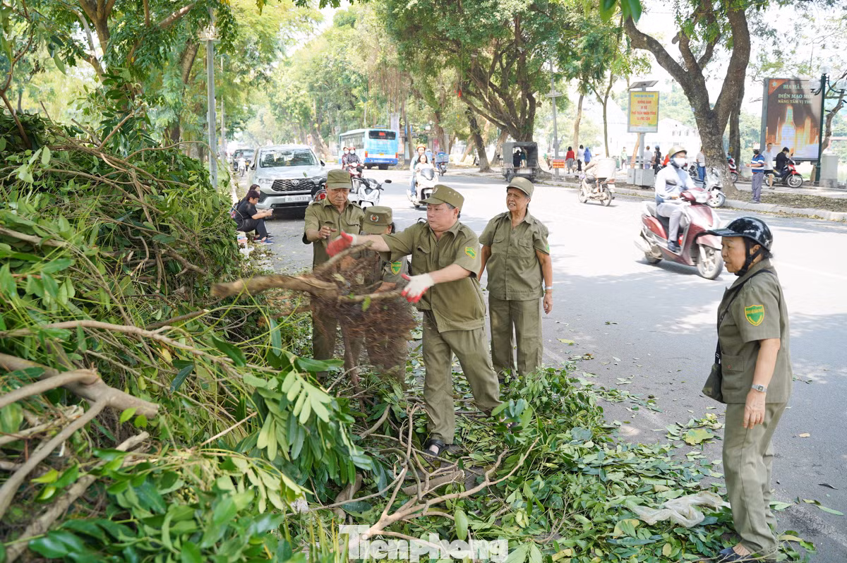 Từ sáng sớm, lực lượng bảo vệ dân phố phường Nguyễn Du (quận Hai Bà Trưng) đã không quản khó khăn, tích cực thu dọn những cây xanh đổ ngã trên phố Quang Trung.