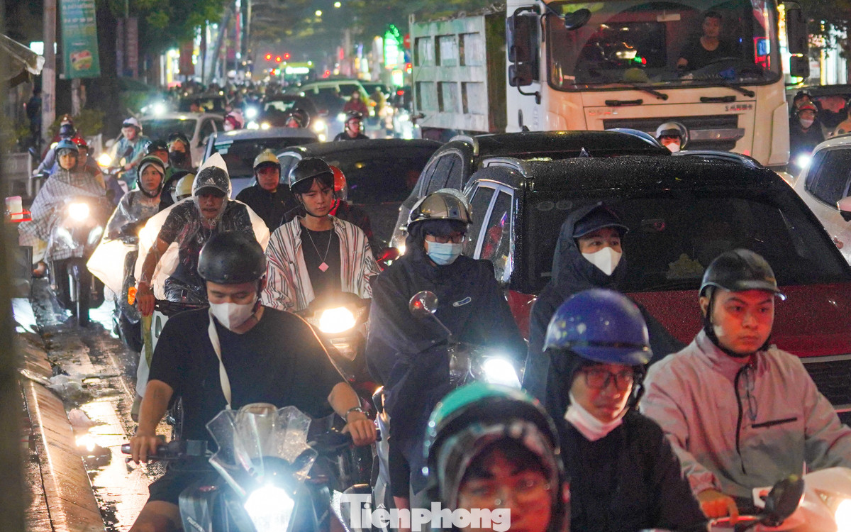 Ôtô, xe máy chen chúc, nhích từng chút một trong cơn mưa cuối ngày.