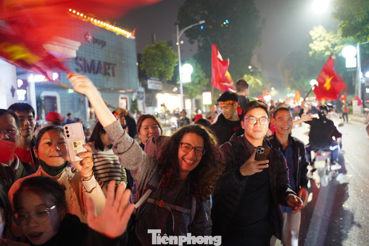 Nhiều du khách mặc áo cờ Việt Nam, tay cầm lá cờ ăn mừng chiến thắng.