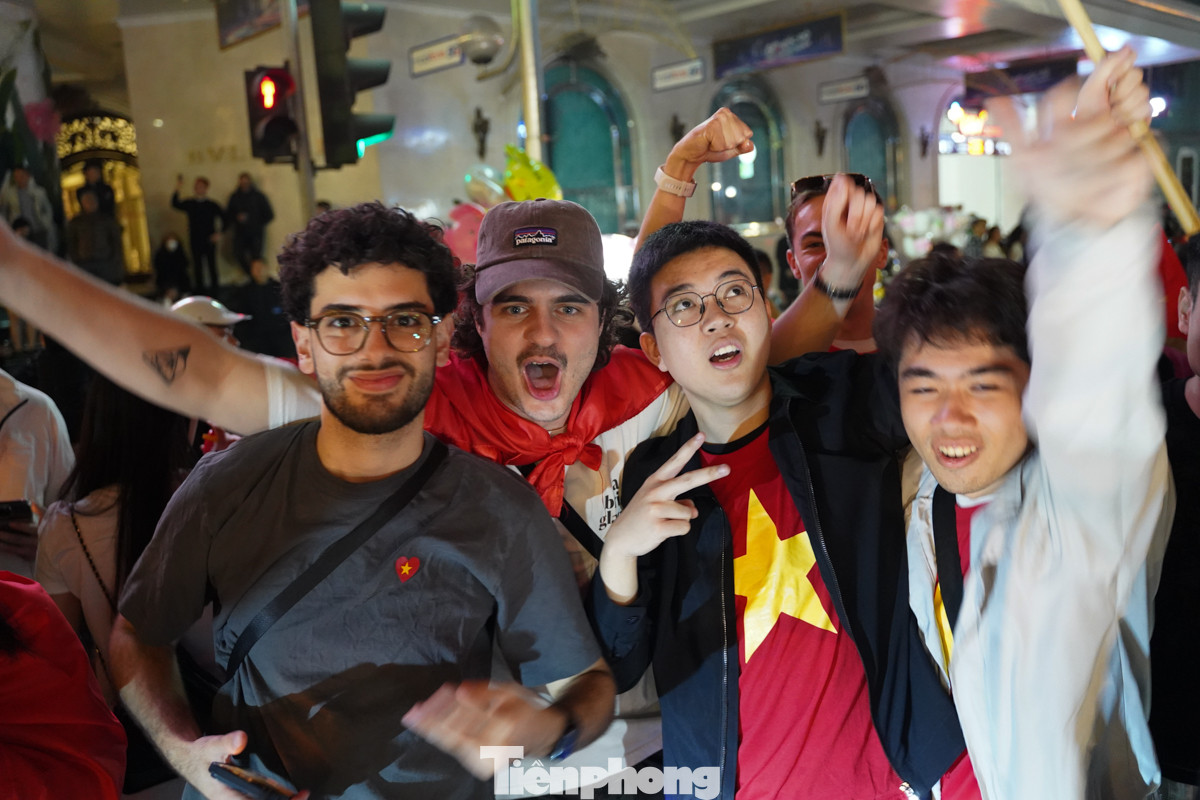 Nhiều du khách mặc áo cờ Việt Nam, tay cầm lá cờ ăn mừng chiến thắng.