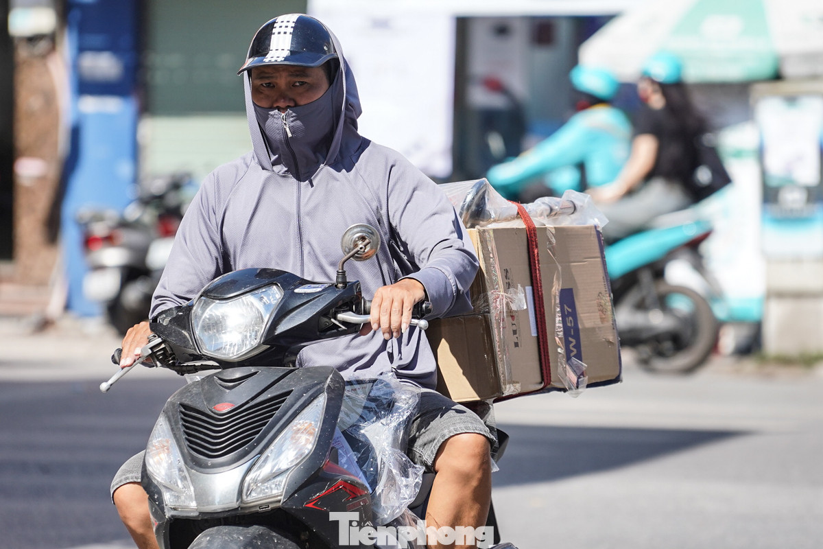 Các tài xế giao hàng cũng phải trang bị áo chống nắng, trùm kín từ trên đầu để có thể làm việc dưới cái nắng gay gắt ở Hà Nội.