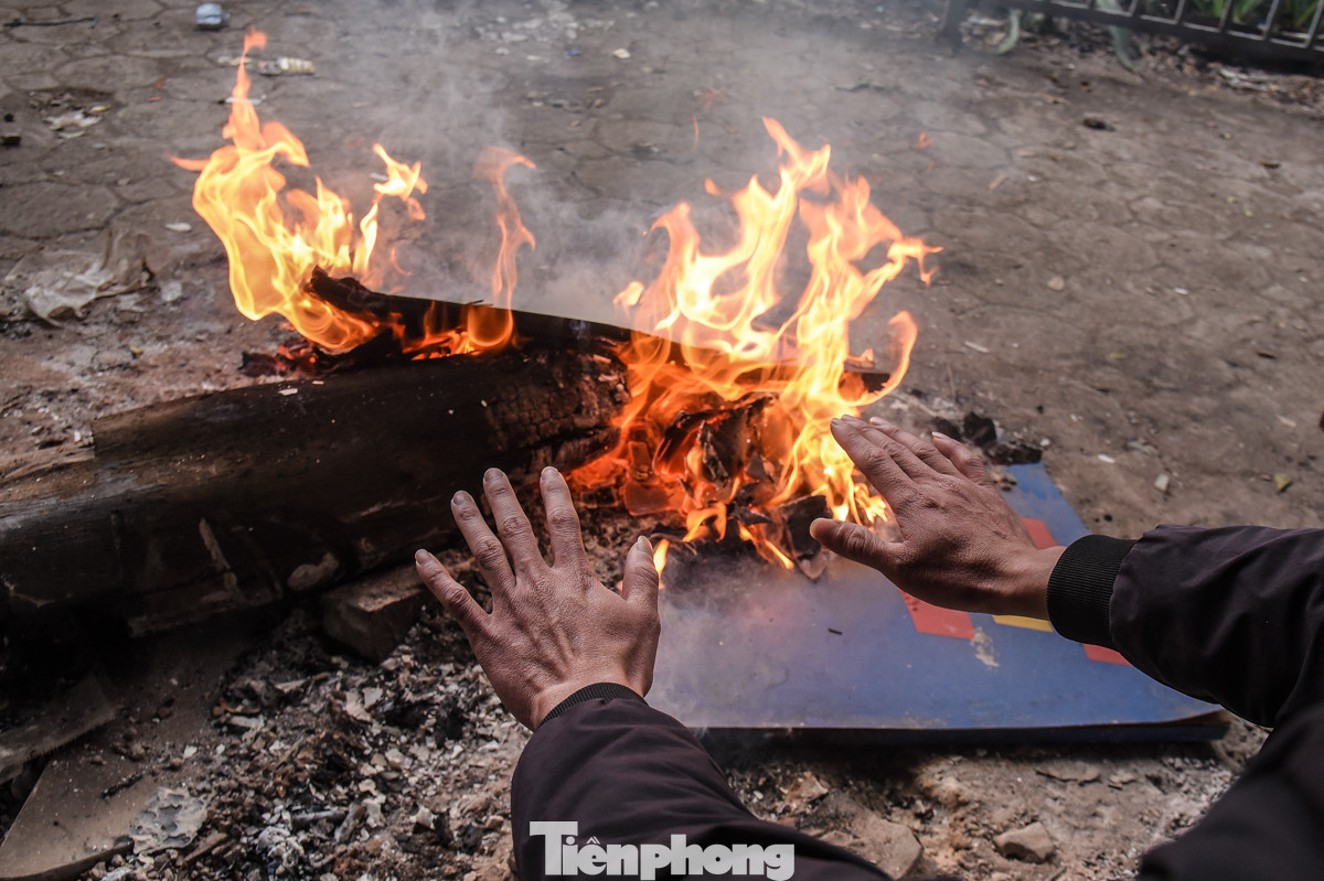 Dưới các chân cầu, người lao động đốt lửa sưởi ấm.