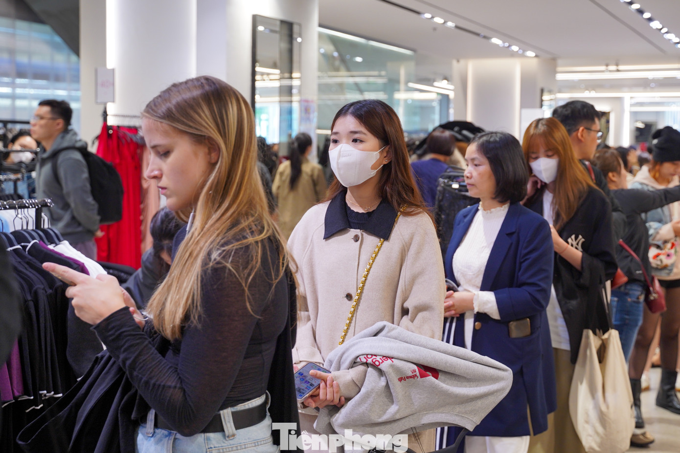 Chị Bùi Thị Như Nguyệt (áo trắng, đeo khẩu trang) đã xếp hàng hơn 1 tiếng để chờ thanh toán chiếc áo. "Hôm nay giá giảm 40% so với mức giá bình thường, mình đã canh nhiều ngày đến hôm nay mới mua được. Tối qua canh online thì hết hàng", chị Nguyệt nói.