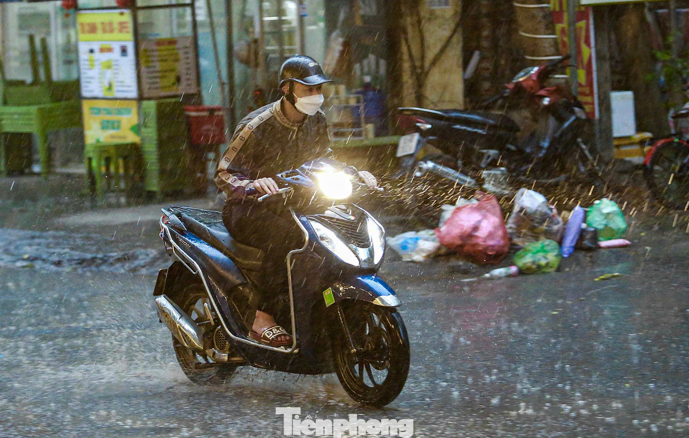 Ghi nhận PV Tiền Phong từ đầu giờ sáng, cơn mưa lớn bất ngờ đổ xuống đúng vào giờ cao điểm khiến nhiều người trở tay không kịp, chưa chuẩn bị áo mưa, gây khó khăn trong việc di chuyển.