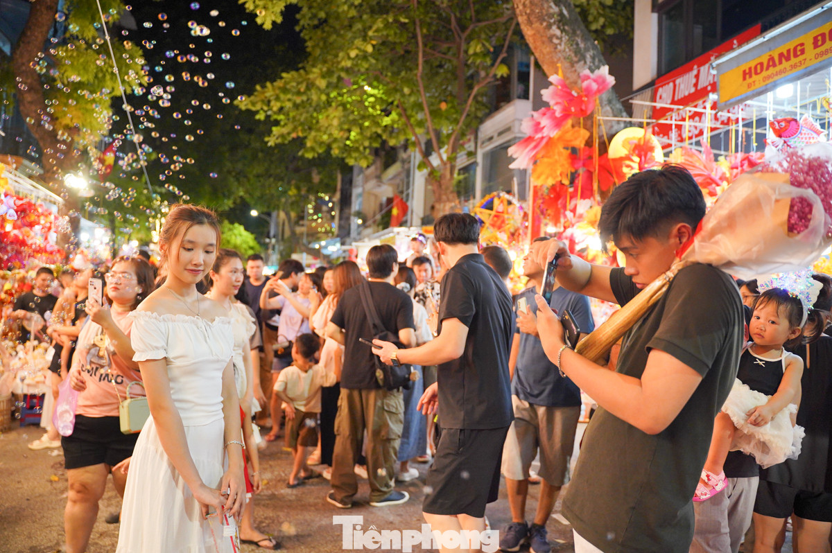 Dòng người đổ về phố Hàng Mã đông nghịt, chen chúc nhau để có được một góc ảnh đẹp.