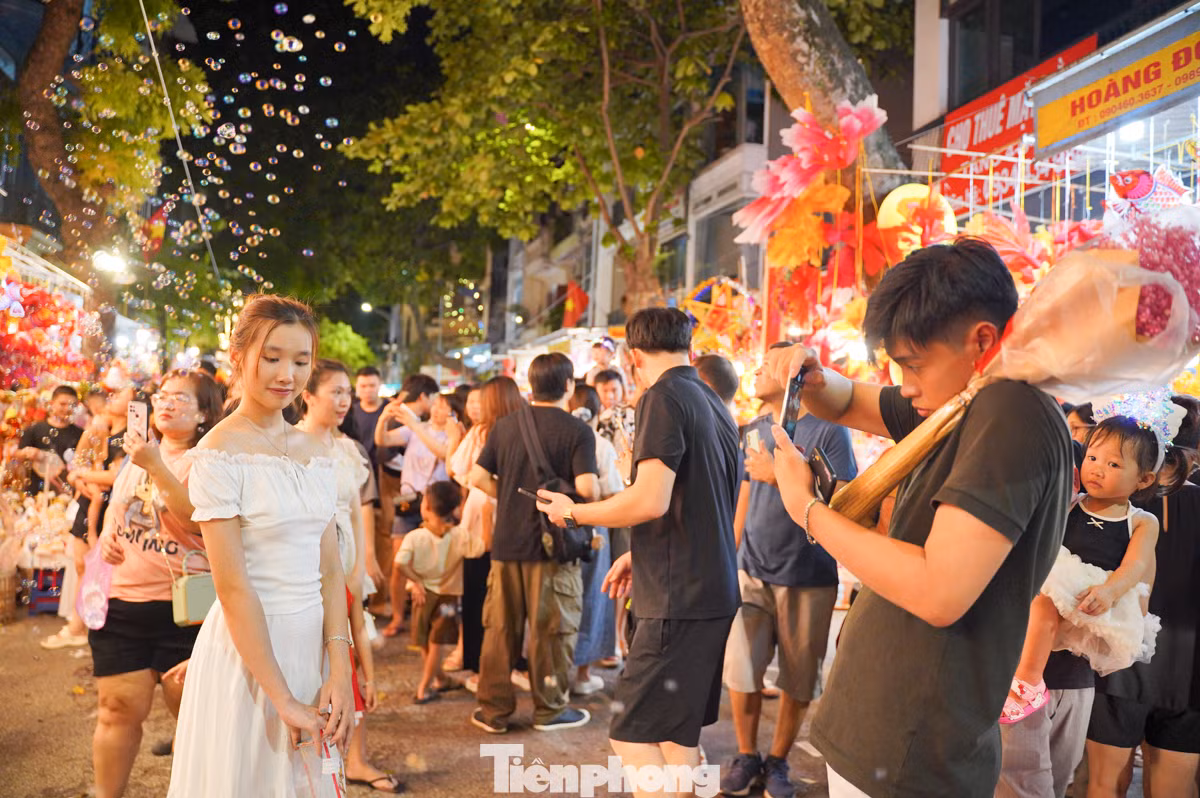 Dòng người đổ về phố Hàng Mã đông nghịt, chen chúc nhau để có được một góc ảnh đẹp.