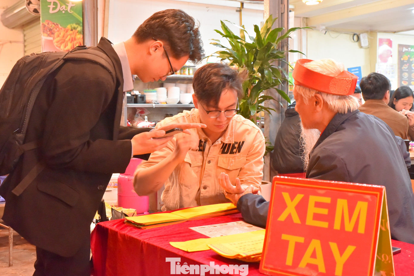 Các cụ già viết sớ, xem tay phục vụ người dân đến lễ.