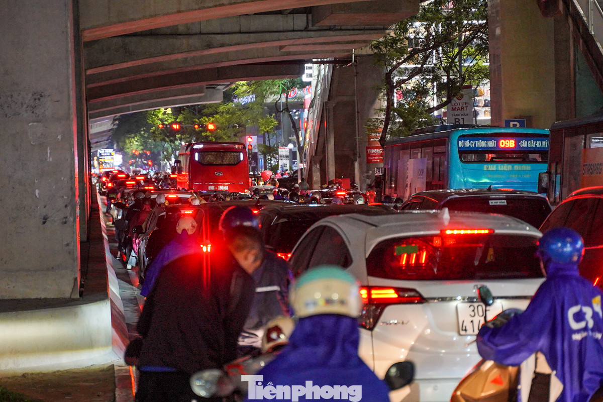 Dòng người nối đuôi nhau trong cơn mưa trên đường Cầu Giấy.