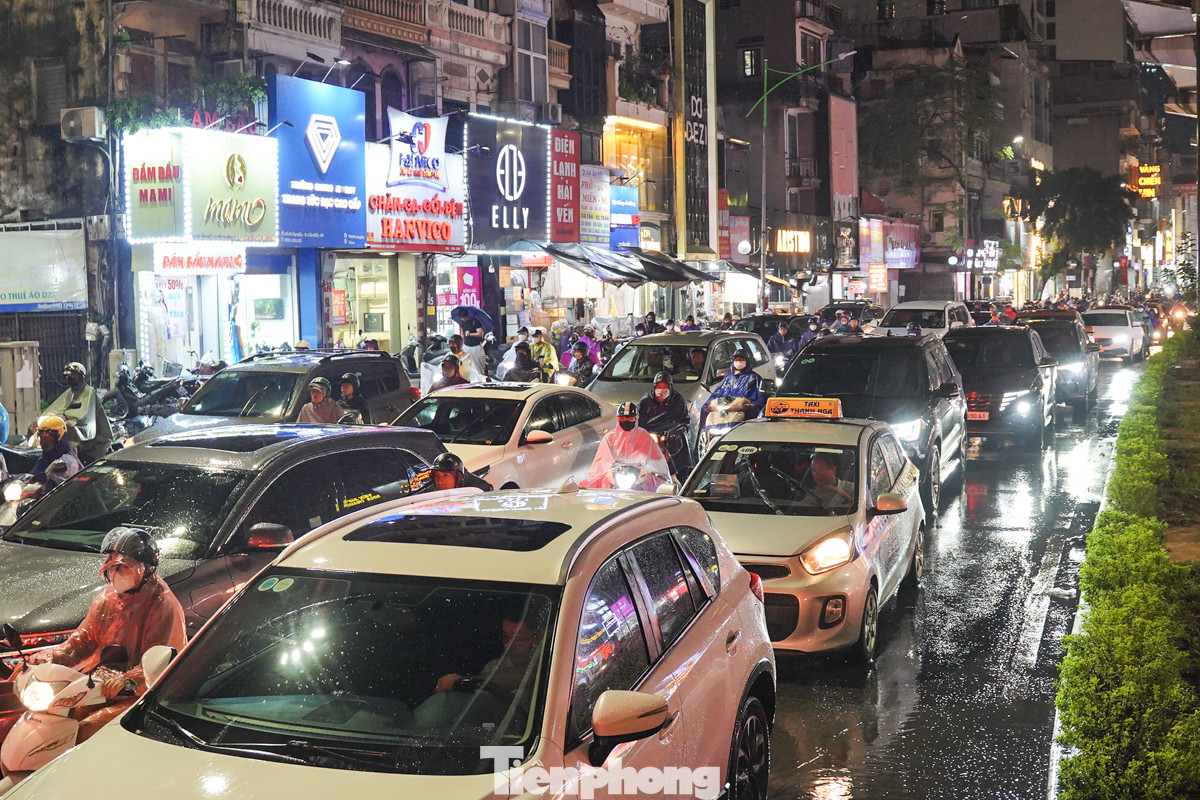 Dòng người nối đuôi nhau trong cơn mưa trên đường Cầu Giấy.