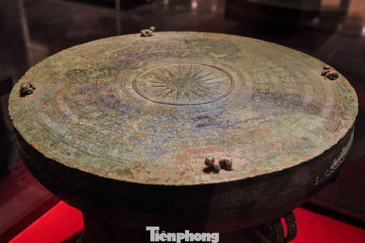 Trống đồng, có niên đại từ thế kỷ I-III Trước Công nguyên, là hiện vật tiêu biểu của nền văn hóa Đông Sơn. Phần trung tâm của mặt trống được trang trí hình mặt trời với 18 tia tỏa ra xung quanh, tượng trưng cho sự sống và sức mạnh.