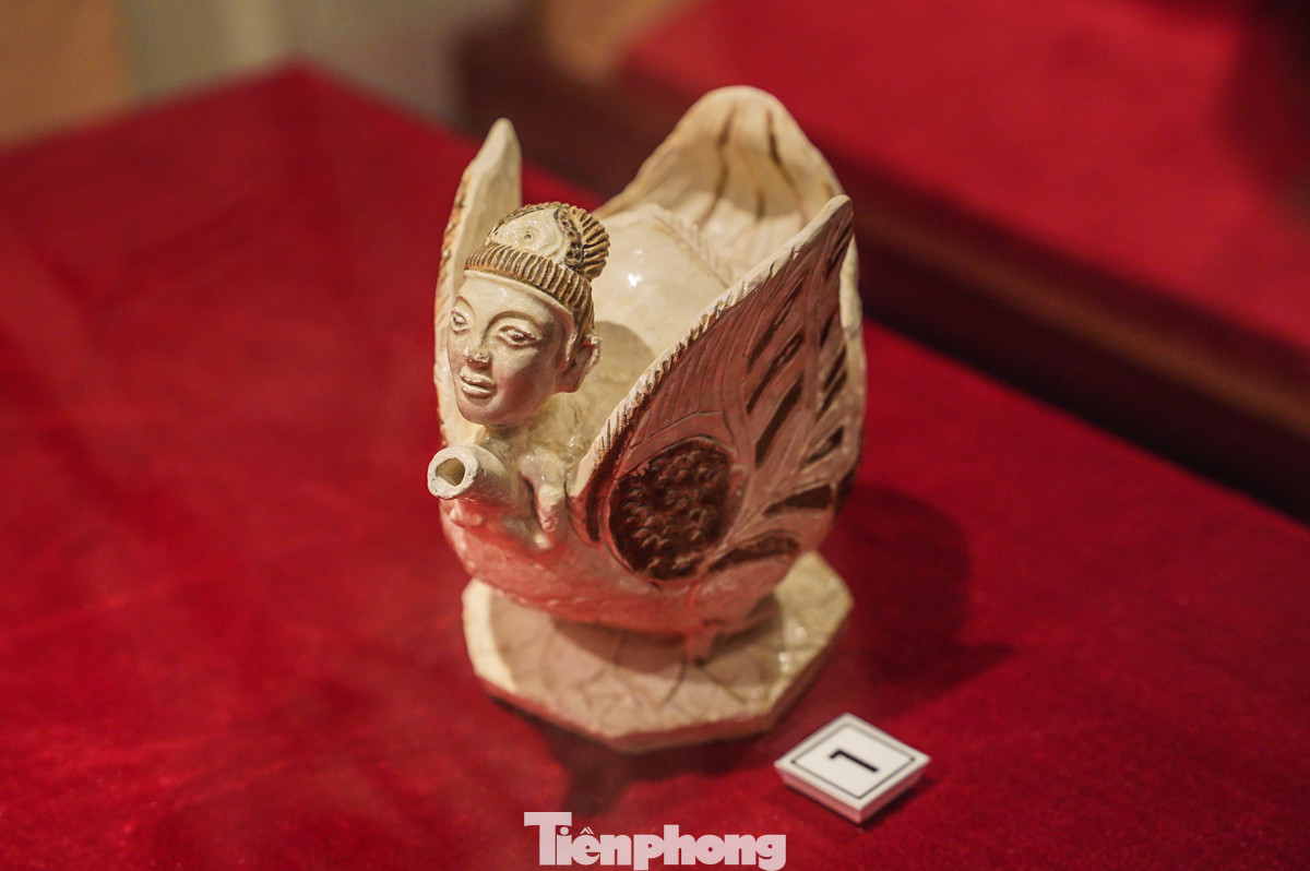 Đây là chiếc chuyên rượu bằng gốm, có niên đại từ thế kỷ XI-XIII, được phủ men trắng và trang trí bằng các họa tiết nâu đặc trưng của thời kỳ Lý - Trần. Chiếc chuyên rượu này nổi bật với phần đầu người được đắp nổi ở phía trước. Trong giai đoạn này, các sản phẩm gốm men trắng vẽ nâu không chỉ được sử dụng trong sinh hoạt hàng ngày mà còn mang ý nghĩa tâm linh và văn hóa, được sử dụng trong các nghi lễ.