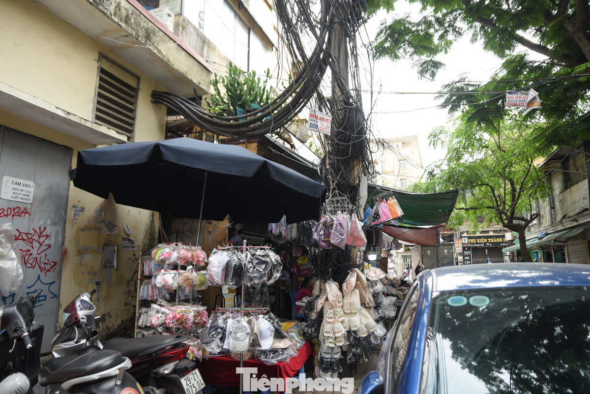 Dây điện chằng chịt sát tường, lan can khu tập thể cũ tại ngõ A8 Tôn Thất Tùng. Thậm chí có người còn bất chấp nguy hiểm bán hàng ngay dưới cột điện.