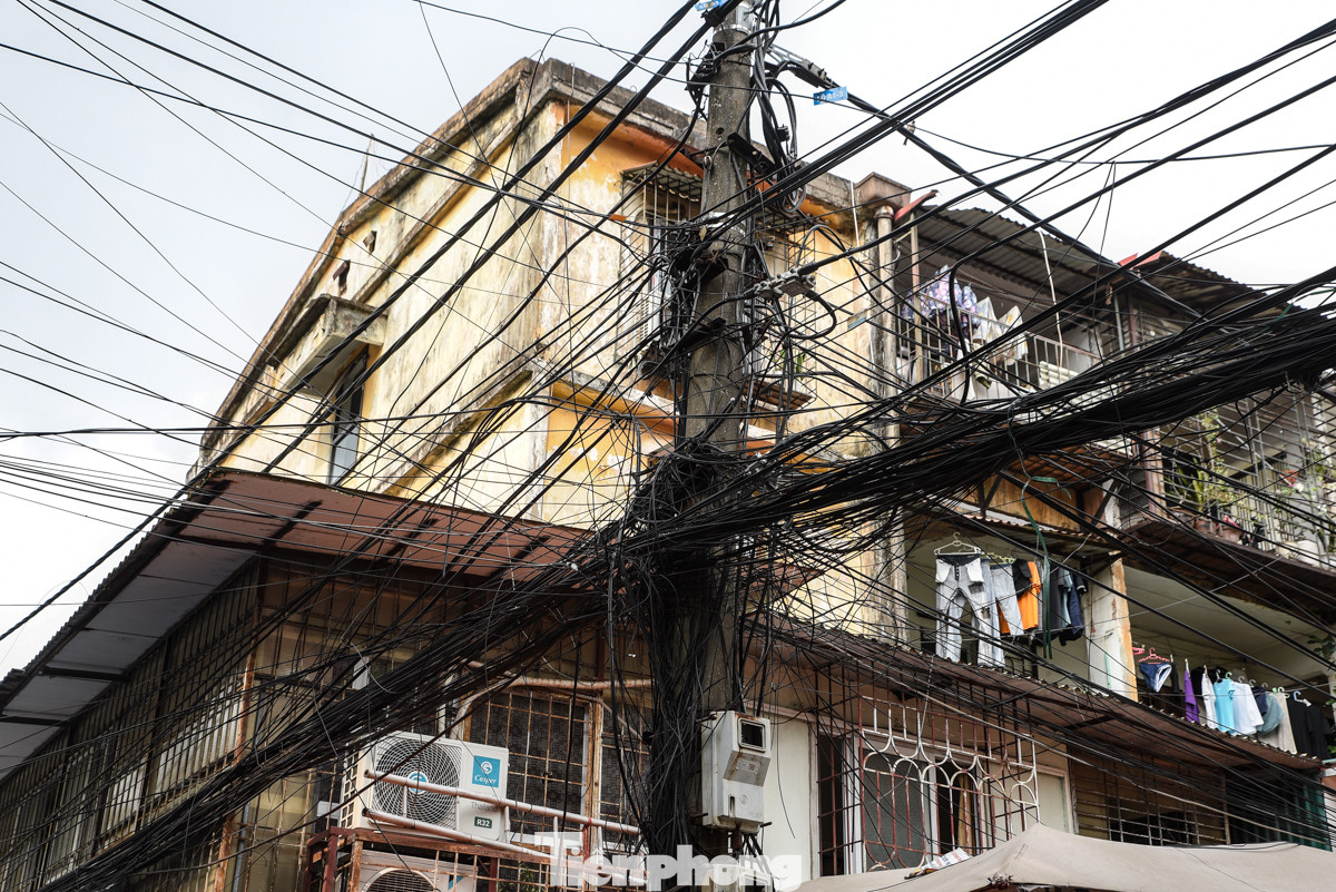 Dây điện chằng chịt sát tường, lan can khu tập thể cũ tại ngõ A8 Tôn Thất Tùng. Thậm chí có người còn bất chấp nguy hiểm bán hàng ngay dưới cột điện.