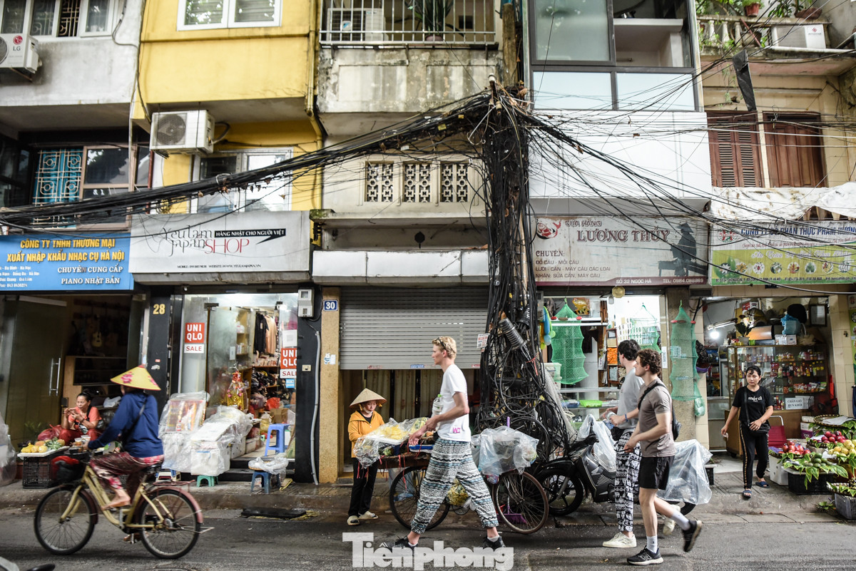 Tại đường Ngọc Hà (quận Ba Đình) những búi dây cáp, dây điện "trùng" xuống cả biển hiệu kinh doanh của các hộ dân.