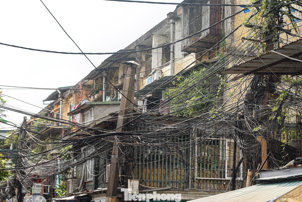 Dây điện chằng chịt sát tường, lan can khu tập thể cũ tại ngõ A8 Tôn Thất Tùng. Thậm chí có người còn bất chấp nguy hiểm bán hàng ngay dưới cột điện.