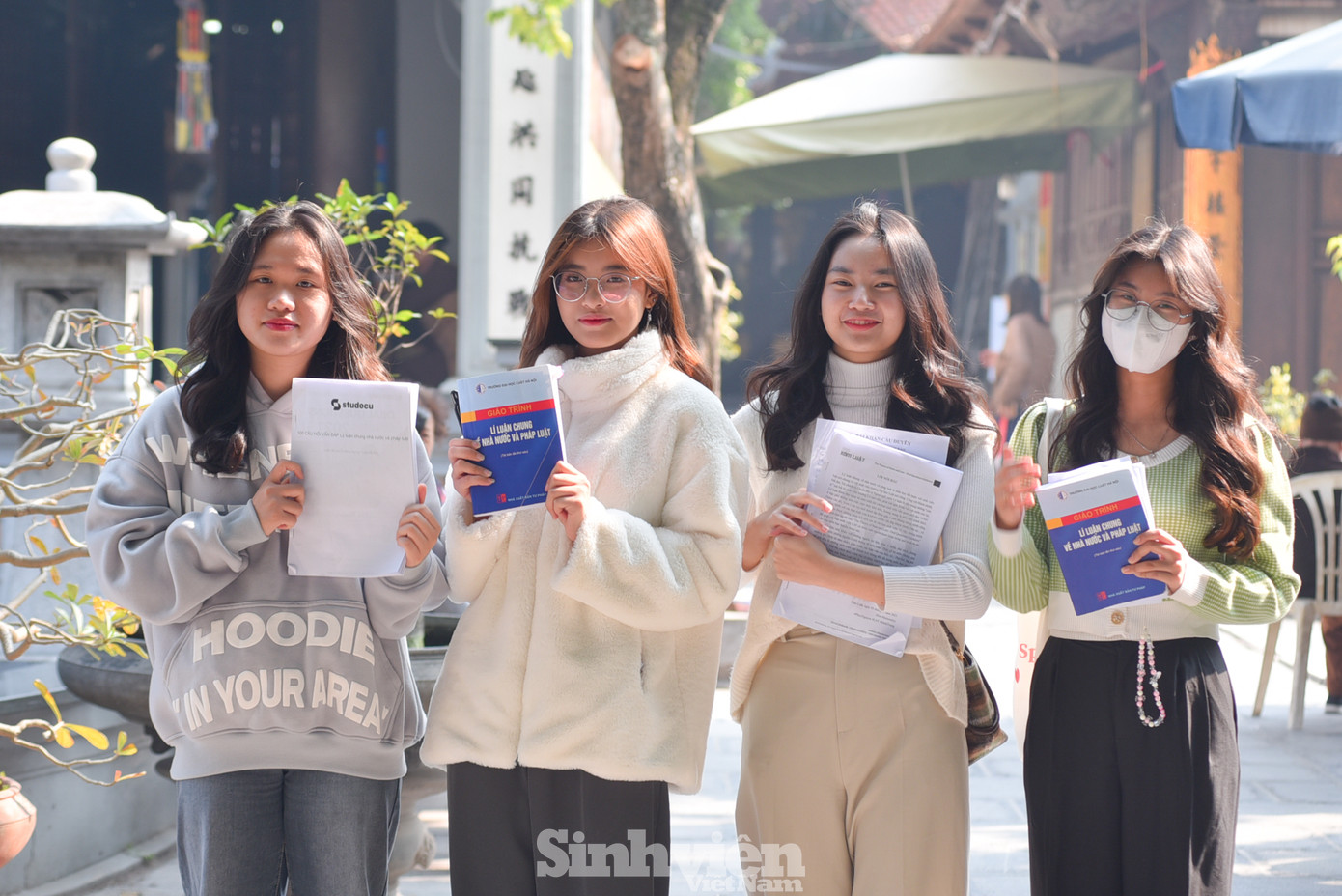 Nhóm 4 bạn sinh viên trường ĐH Luật Hà Nội, ngoài đến cầu duyên, các bạn còn mang theo giáo trình để mong mắn mắn, kỳ thi sắp tới thuận lợi. "Mình mong rằng cả 4 đứa sẽ qua môn, tình duyên không lận đận", bạn Hoàng Diệu Linh (áo xanh, đeo khẩu trang) chia sẻ.