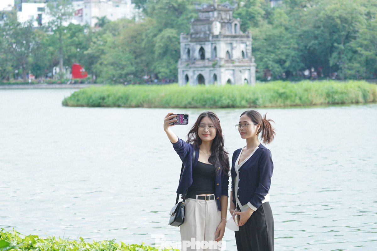 Từ sáng sớm, Giang và bạn thân đã háo hức khoác lên mình chiếc áo gió mỏng nhẹ và cùng nhau đến hồ Gươm. Cái lạnh se se của buổi sáng khiến cả hai cảm thấy vô cùng thích thú. "Hôm nay thời tiết se lạnh, nhưng khá thích. Bọn mình lựa chọn đi ngắm cảnh, uống tách cà phê", Giang chia sẻ.