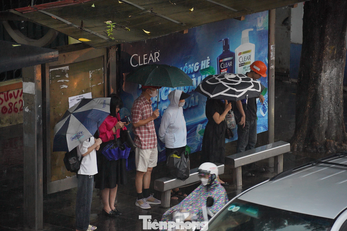 Trời mưa, đường tắc khiến những người chờ xe buýt phải đợi lâu hơn. "Tôi chờ một chuyến xe buýt hết hơn 30 phút, ngày thường chỉ khoảng 10 phút. Mưa này đường rất tắc, các xe di chuyển chậm", chị Nguyễn Thị Hân chia sẻ.