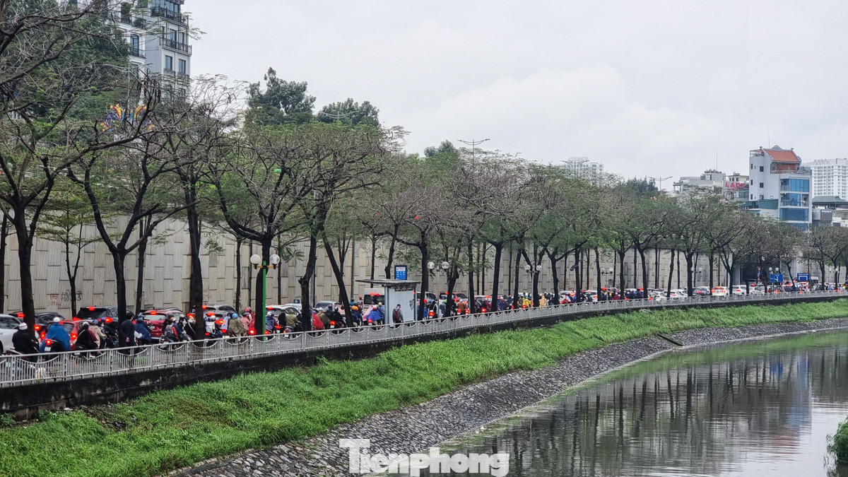 Dọc bờ sông Quan Hoa đông nghẹt các phương tiện, xe máy và ôtô chen nhau nhích từng chút một.