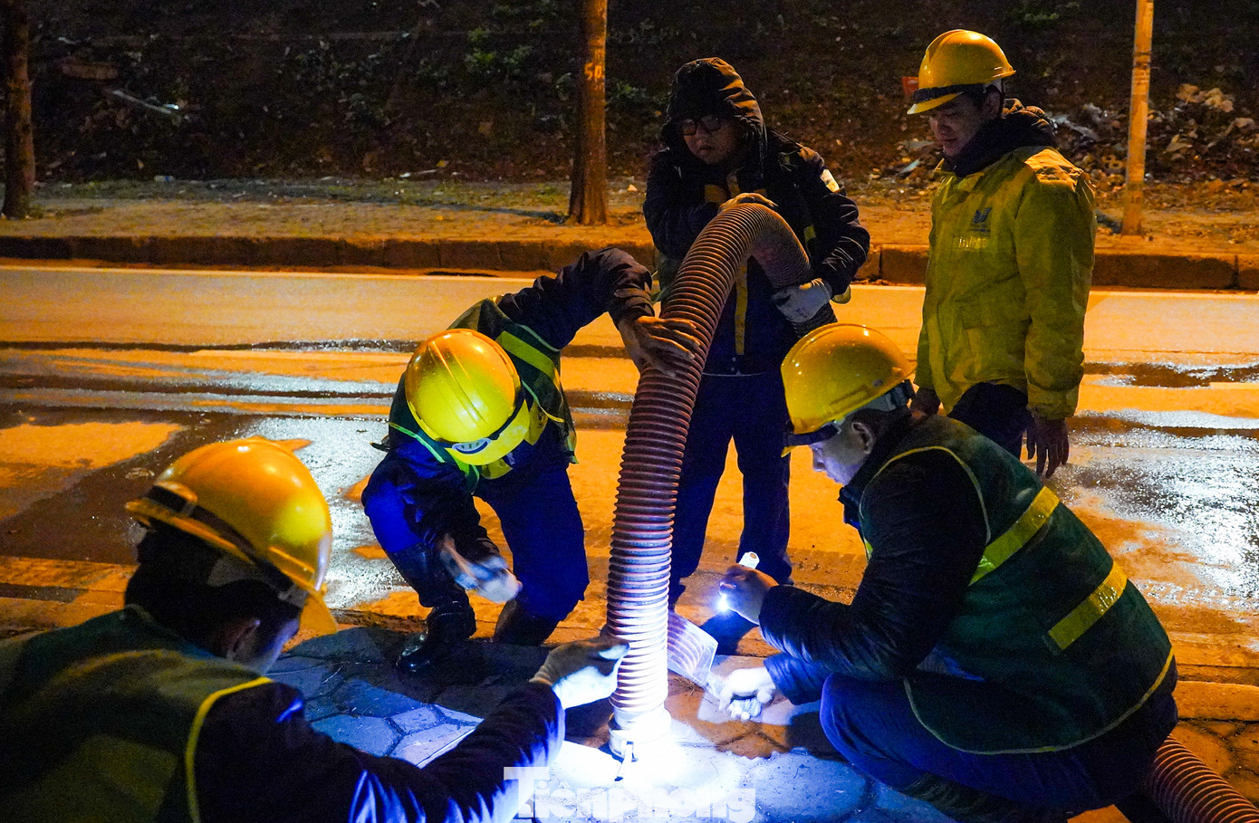 2h sáng, các công nhân môi trường vẫn cặm cụi làm việc. Hà Nội lúc này lạnh buốt trong màn sương, nhiệt độ hạ xuống chỉ còn 12 độ C.