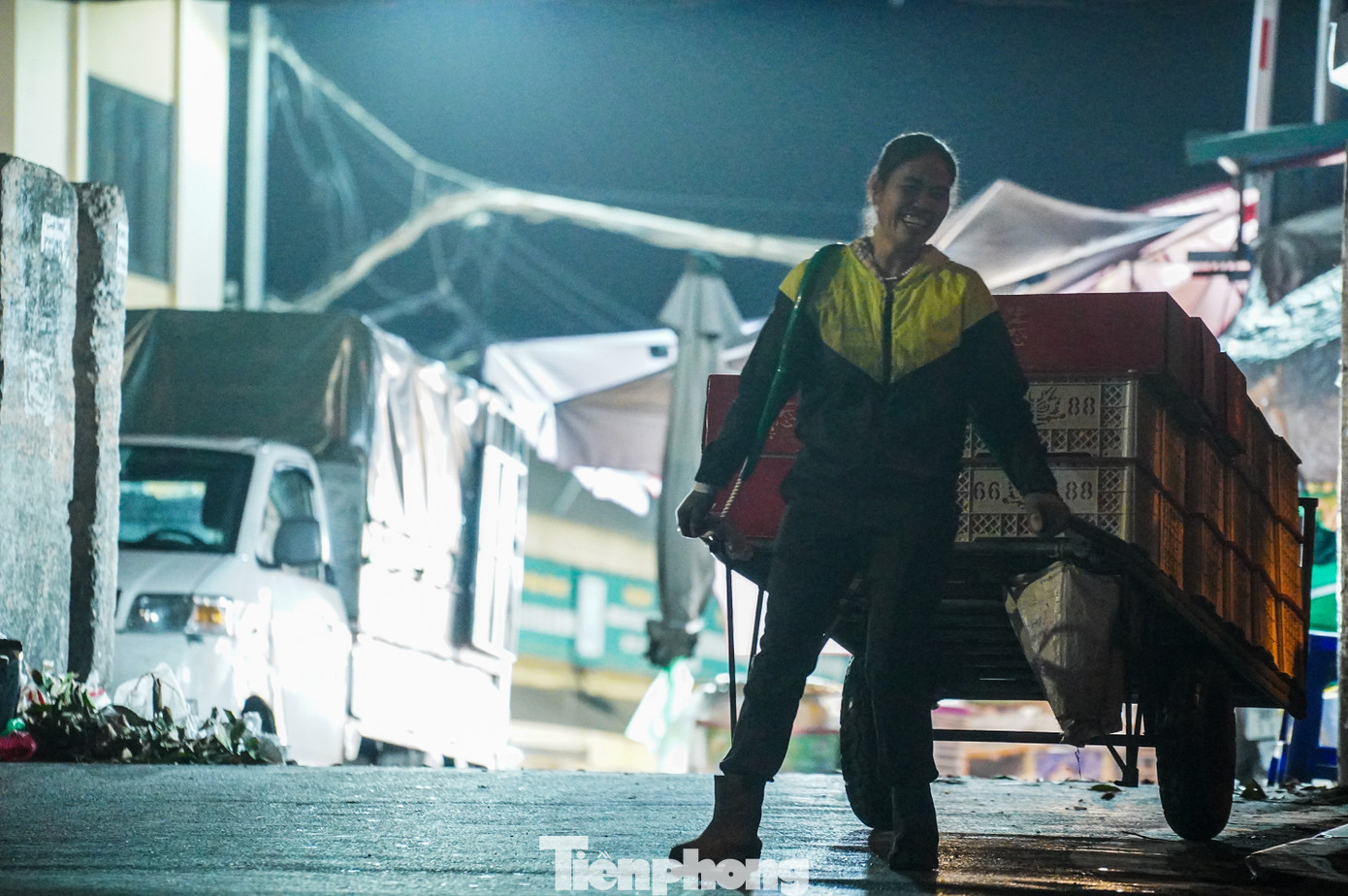 Thời điểm 0h - 2h sáng, hàng hóa và hoa quả đổ về các chợ đầu mối vẫn ùn ùn đổ về. Dù thời tiết giá rét, những lao động làm nghề bốc vác vẫn miệt mài làm việc, trên môi vẫn nở nụ cười.