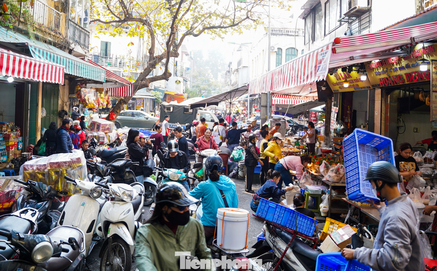 Từ sáng sớm 21/1 (tức 22 tháng Chạp), những cửa hàng bán gà ngậm hoa hồng tại chợ nhà giàu trên phố Gia Ngư và Hàng Bè (quận Hoàn Kiếm) đã tấp nập.