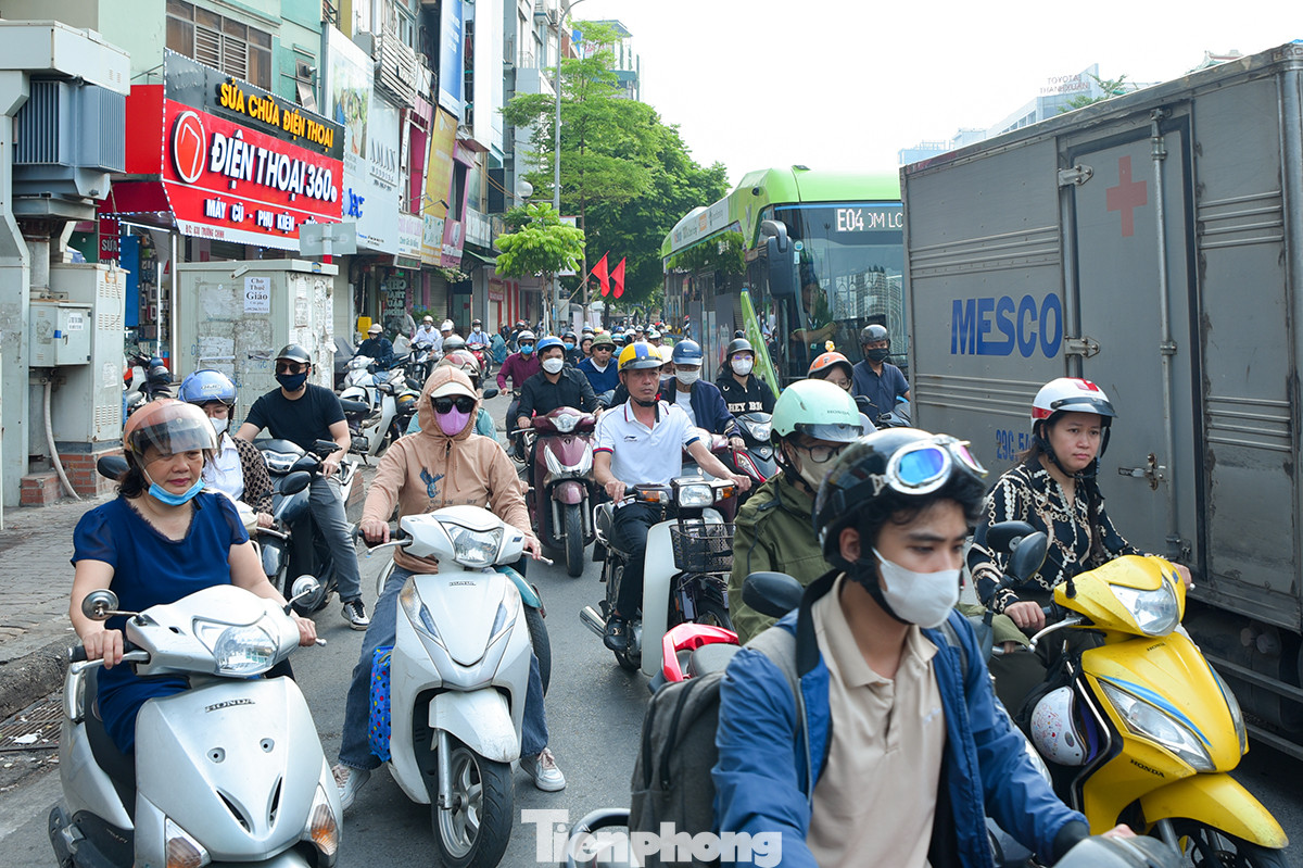 Ôtô nối đuôi nhau, dàn hàng ngang trên đường khiến người điều khiển xe máy phải cố gắng luồn lách qua các điểm hở để tìm lối thoát.