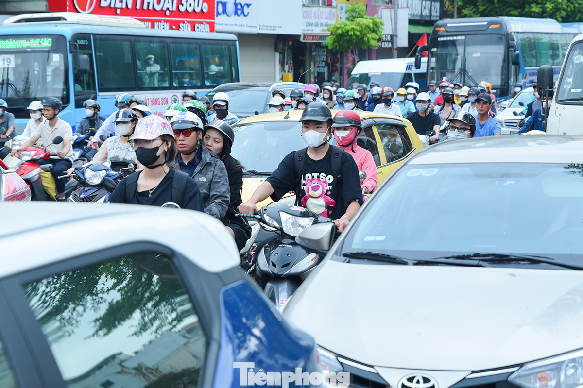 Ôtô nối đuôi nhau, dàn hàng ngang trên đường khiến người điều khiển xe máy phải cố gắng luồn lách qua các điểm hở để tìm lối thoát.