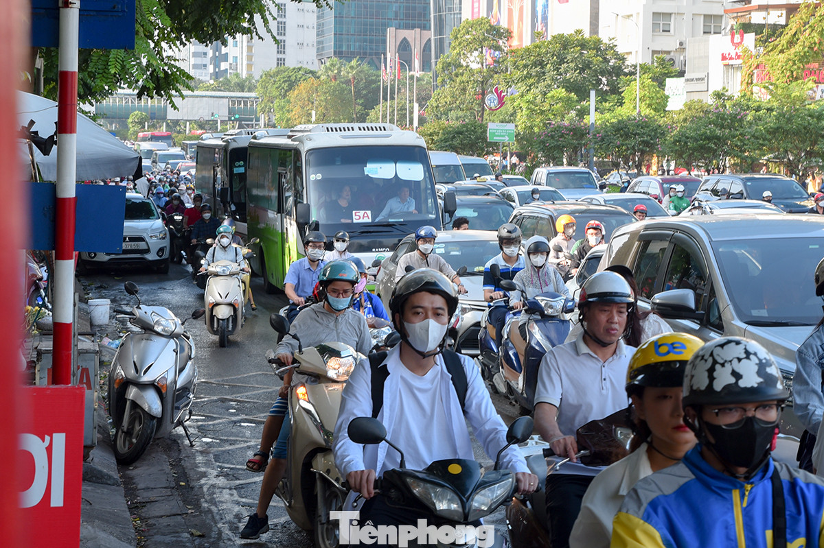 Ôtô nối đuôi nhau, dàn hàng ngang trên đường khiến người điều khiển xe máy phải cố gắng luồn lách qua các điểm hở để tìm lối thoát.