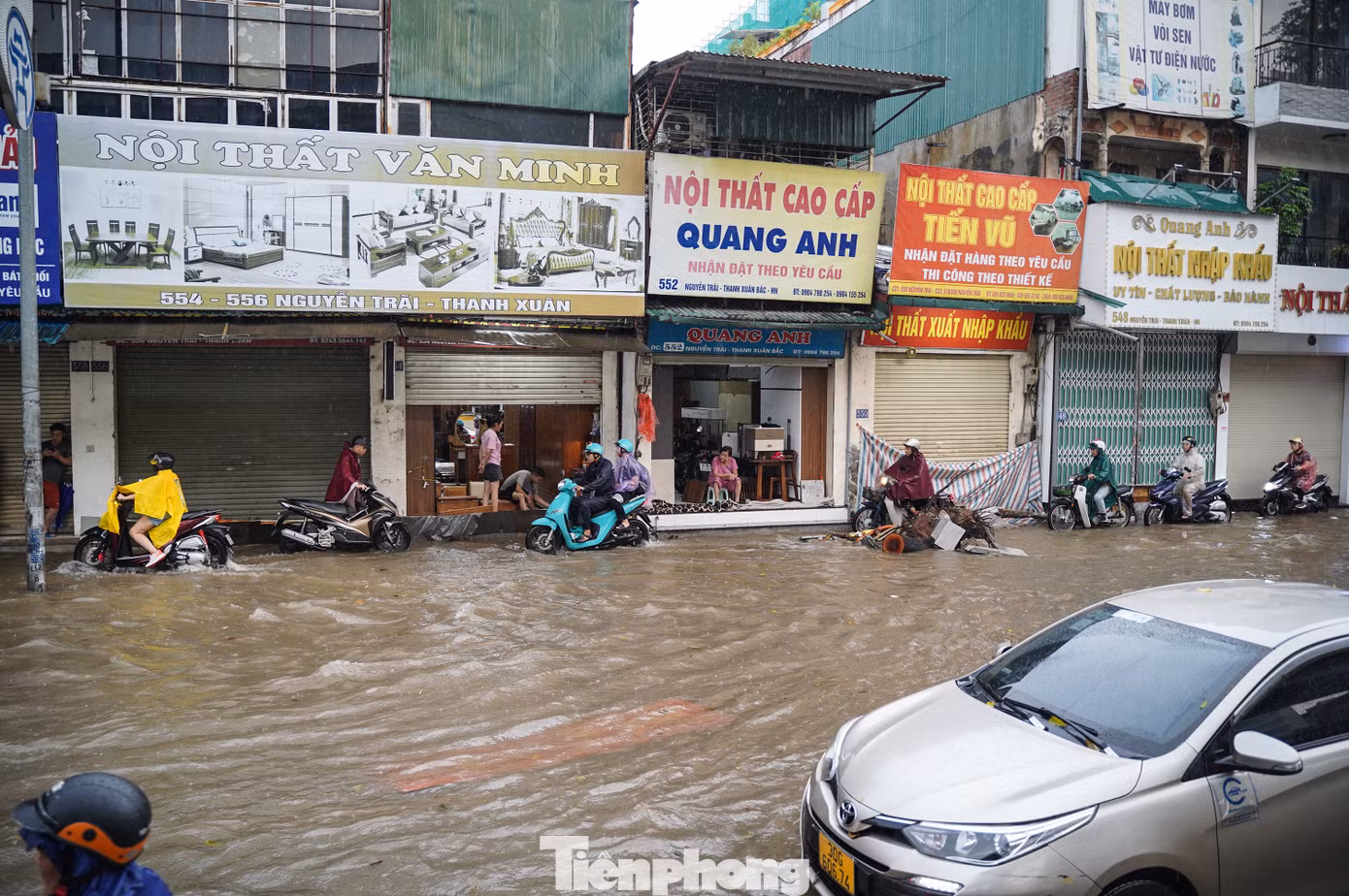 Hàng dài phương tiện nối đuôi đi vào mép đường trên vỉa hè.