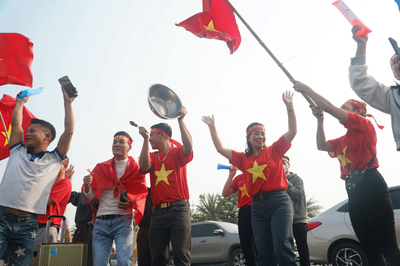 Người dân đón các cầu thủ chuẩn bị đầy đủ băng rôn, áo cờ Tổ quốc.