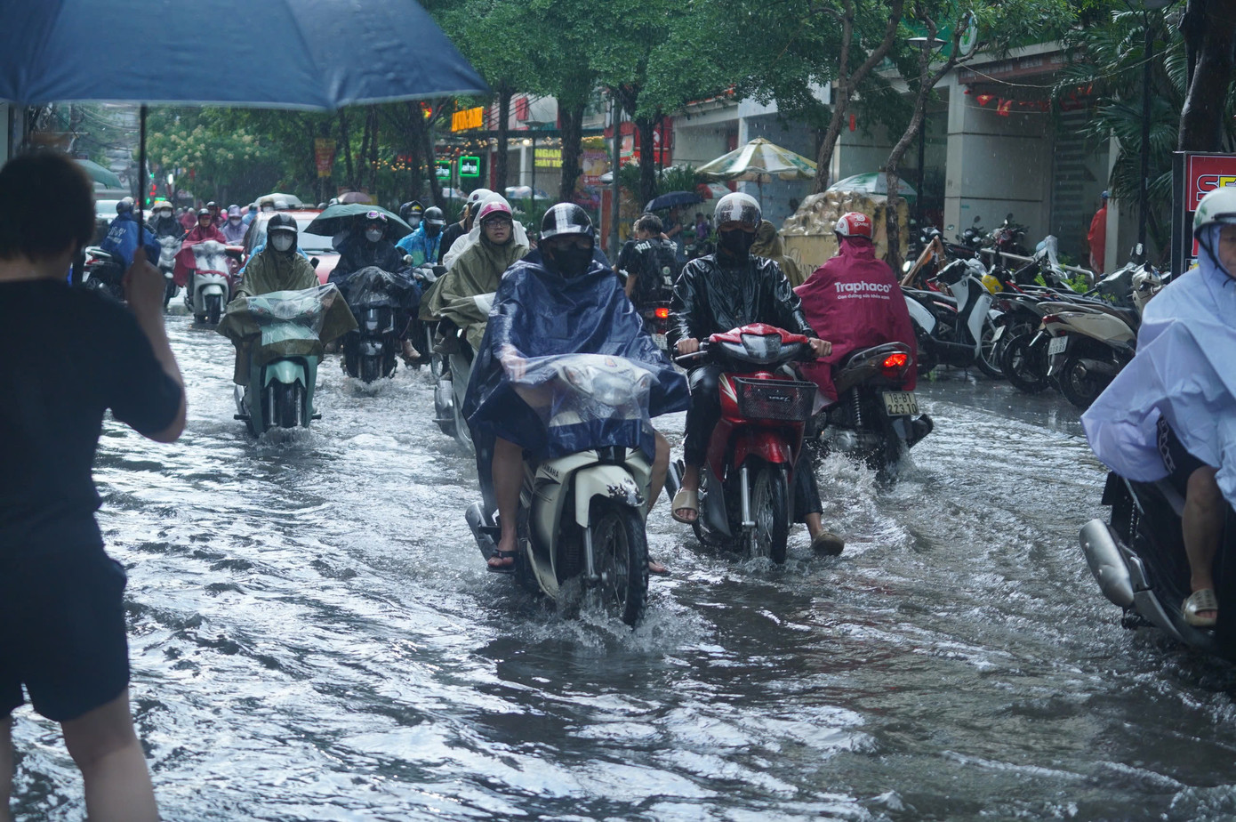 Mưa đã tạnh nhưng nước vẫn lênh láng trên đường khiến giao thông vốn đã ùn tắc, nay lại càng khó khăn hơn.