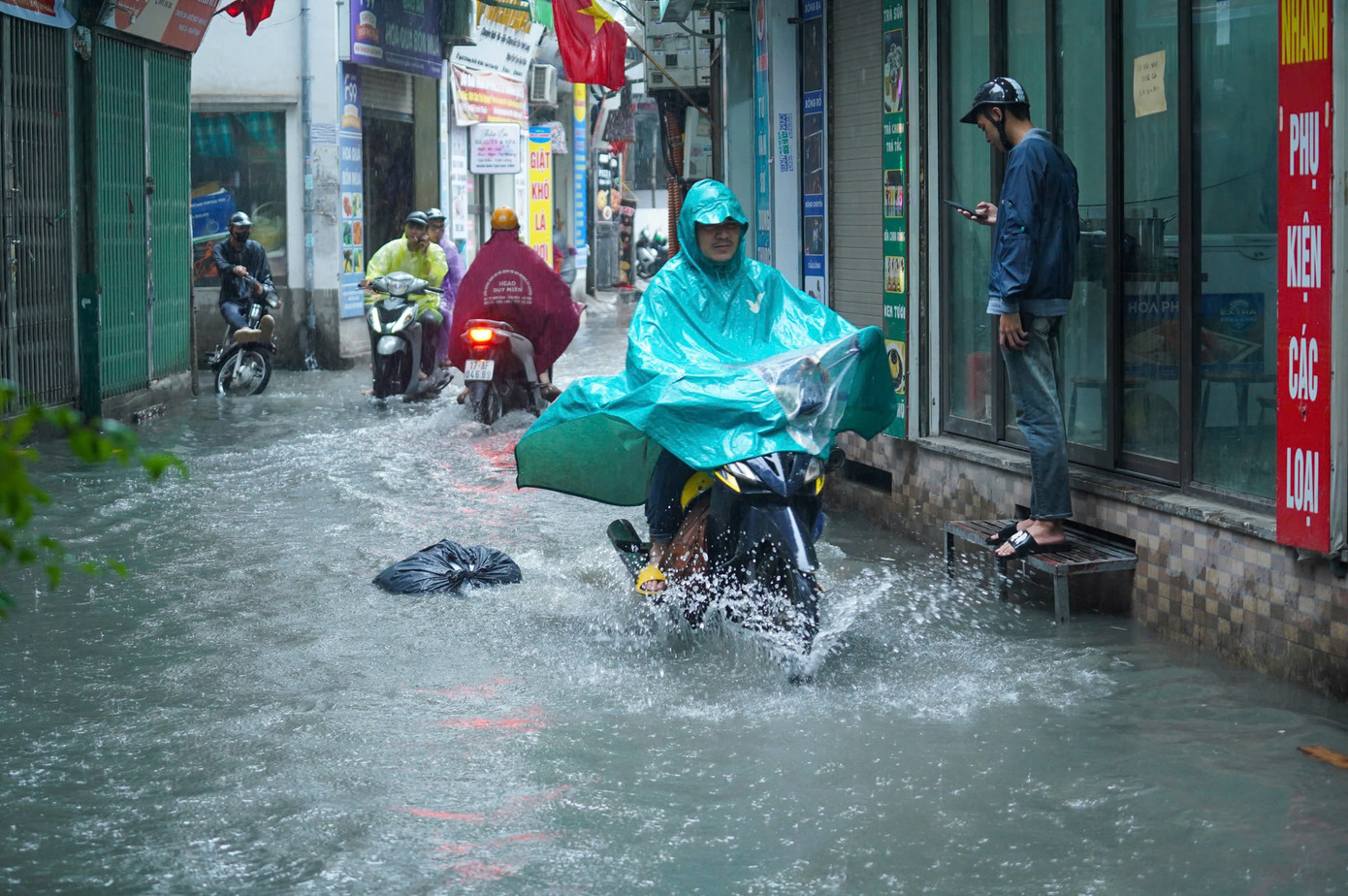 Mực nước dâng cao chừng 25cm gây khó khăn và nguy hiểm cho người tham gia giao thông.