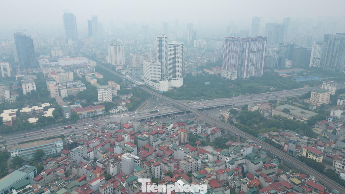 Tại khu nút giao Mai Dịch, bầu trời mịt mù, nhiều toà nhà cao tầng ẩn hiện trong sương.