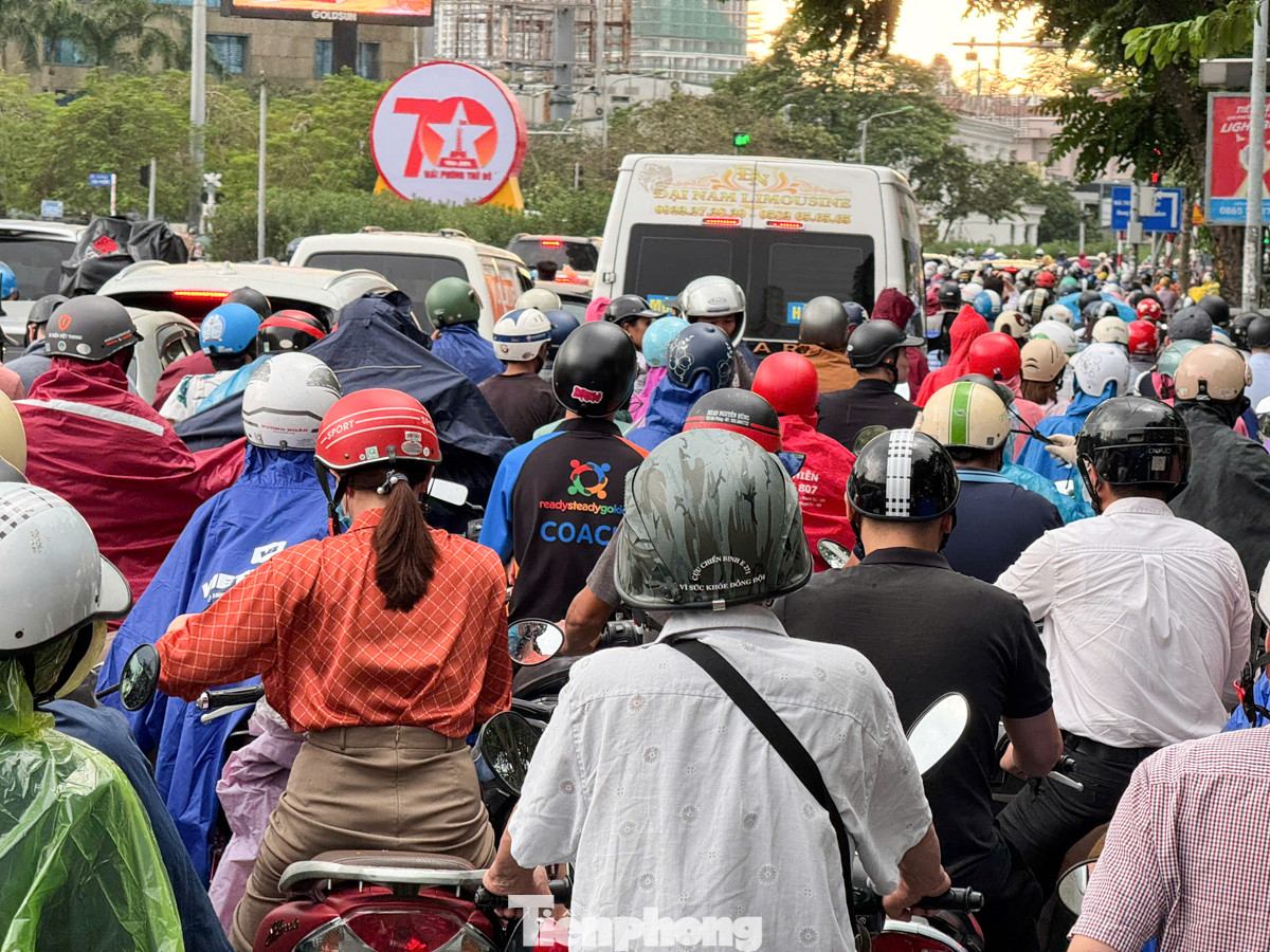 Dòng người nối đuôi nhau trong cơn mưa đúng giờ tan tầm.