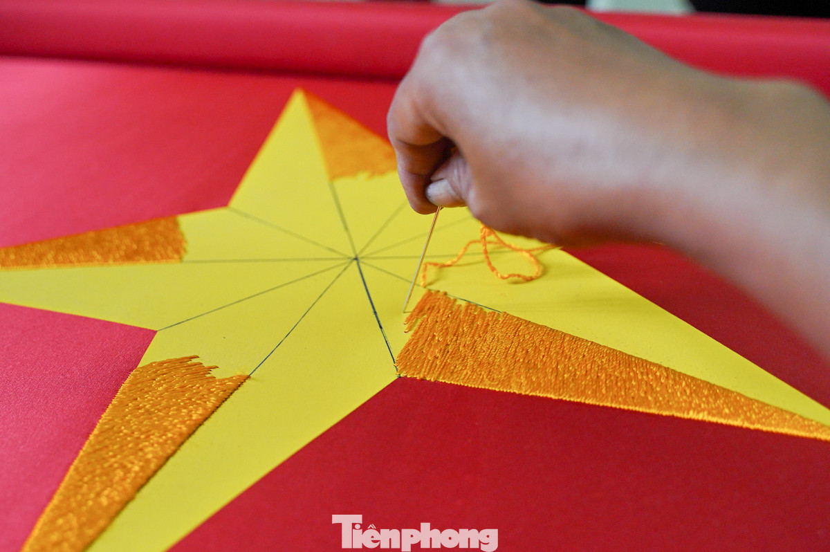 Từng đường kim mũi chỉ đều đặn, chính xác, tạo nên hình ảnh ngôi sao vàng năm cánh rực rỡ trên nền vải đỏ thắm.