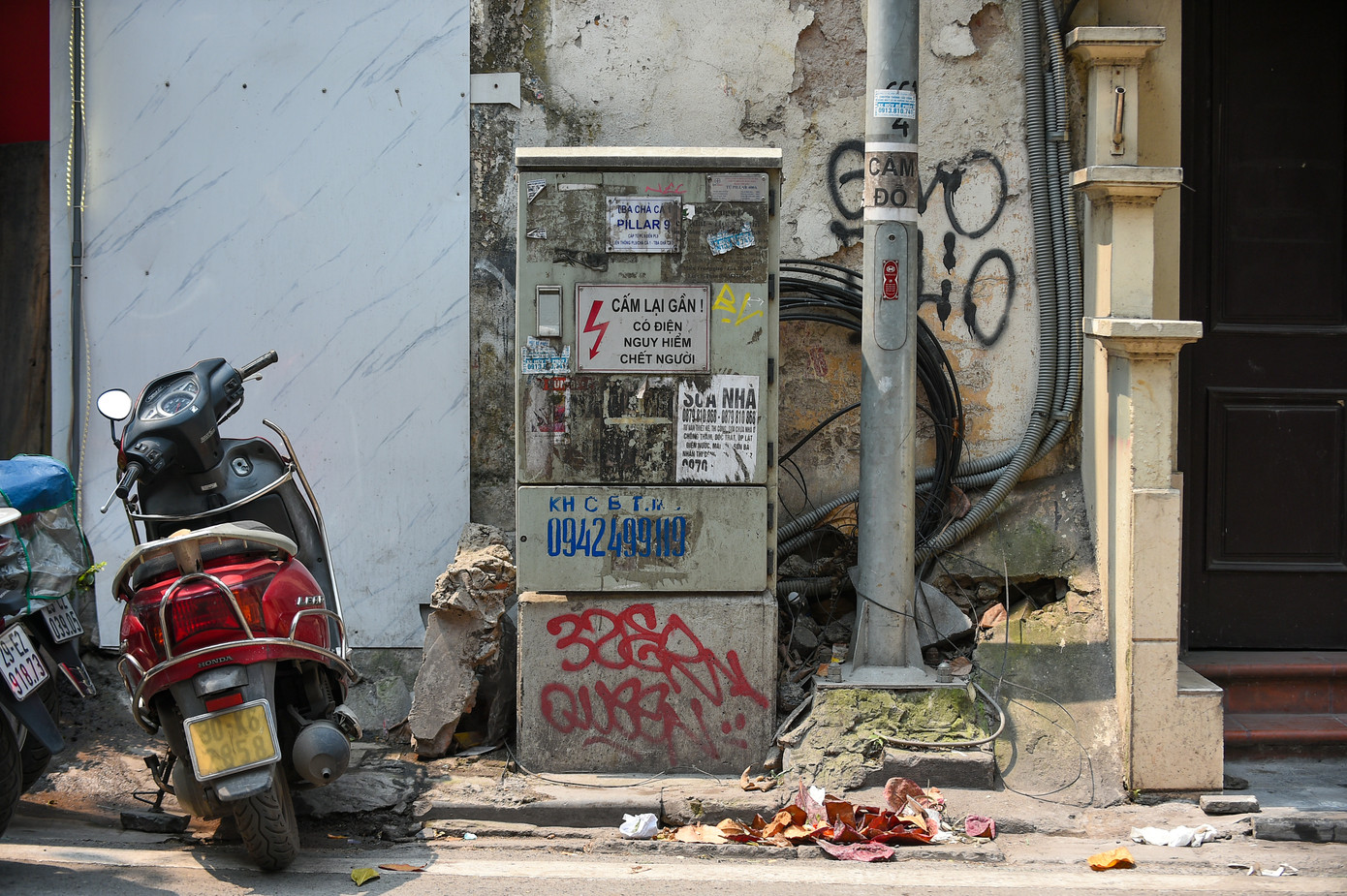 Tủ điện tại khu vực phố Chả Cá (quận Hoàn Kiếm) bị bôi bẩn bởi các tờ rơi quảng cáo dán chằng chịt lên nhau.