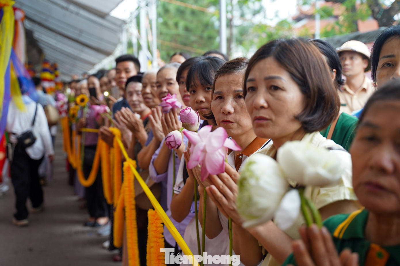 Phật tử trong trang phục chỉnh tề, xếp hàng trang nghiêm trước cổng chùa.