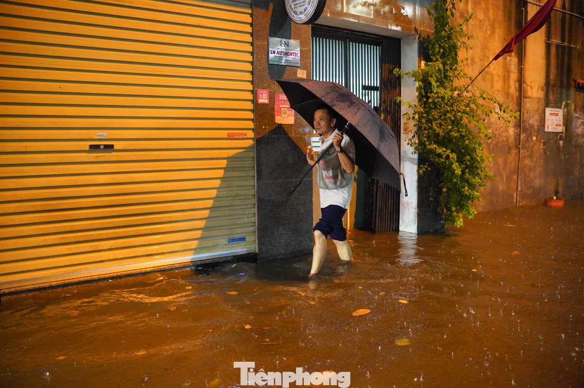 Người dân bì bõm lội nước để về nhà.